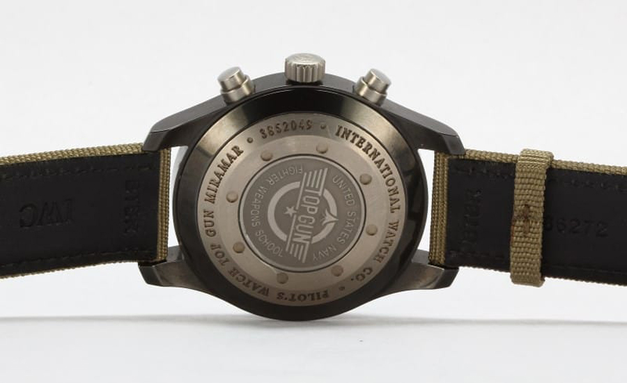 The engravings on the Top Gun Miramar reads “INTERNATIONAL WATCH CO.” and “PILOT’S Replica WATCH TOP GUN MIRAMAR”.